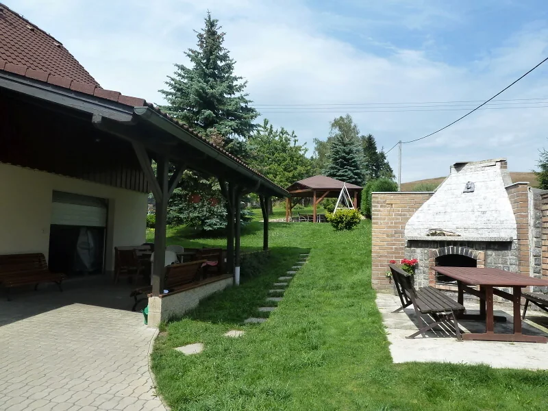 Kryté posezení a venkovní krb na zahradě